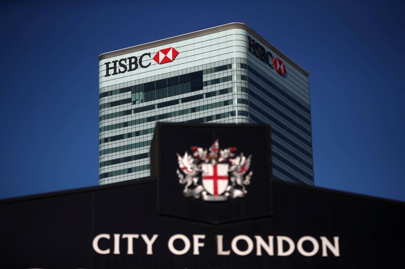 © Reuters. FILE PHOTO: HSBC's building in Canary Wharf is seen behind a City of London sign outside Billingsgate Market in London