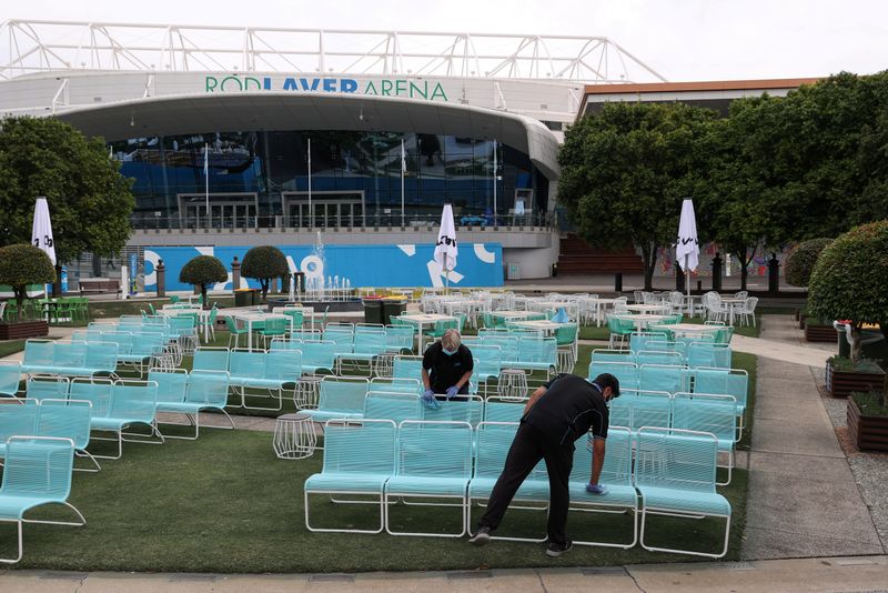 &copy; Reuters. FILE PHOTO: Workers clean a seating area at Melbourne Park after the day&apos;s matches were cancelled in Melbourne