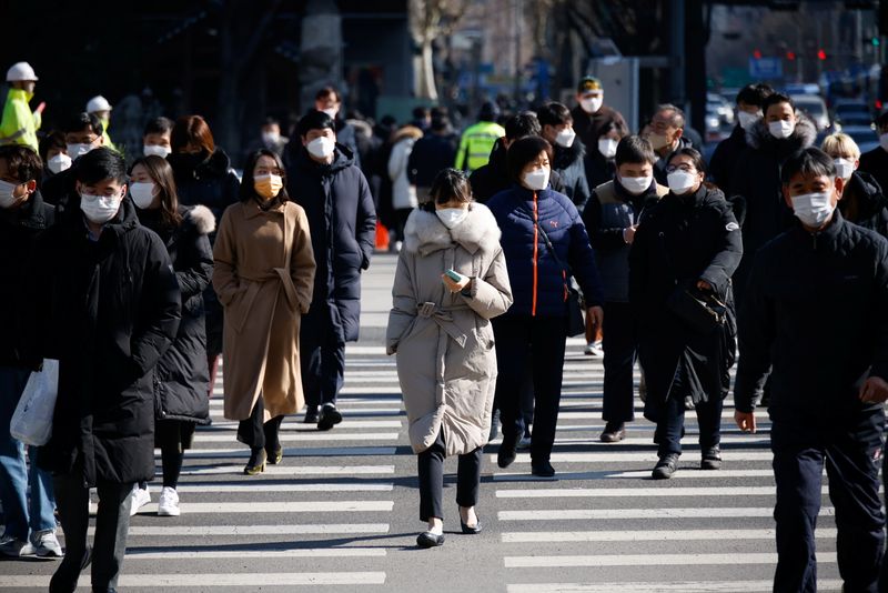 &copy; Reuters. Commuters cross a zebra crossing, amid the coronavirus disease (COVID-19) pandemic in Seoul