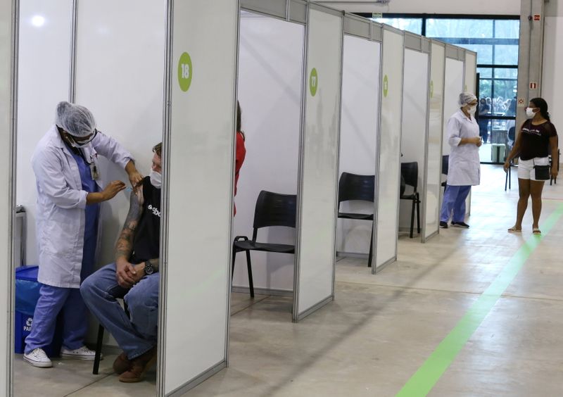 &copy; Reuters. FOTO DE ARCHIVO-Una sanitaria inocula una vacuna contra el coronavirus a un trabajador de la salud en el centro de eventos Positivo de Curitiba, Brasil.