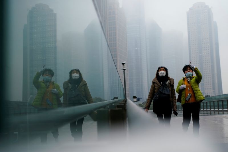 © Reuters. FILE PHOTO: People wearing face masks walk on a street following the coronavirus disease (COVID-19) outbreak, in Shanghai