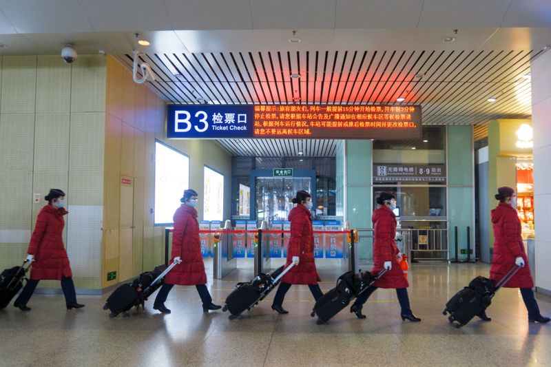 &copy; Reuters. FILE PHOTO:Train attendants walk in Wuhan Railway Station following an outbreak of the coronavirus disease (COVID-19) in Wuhan