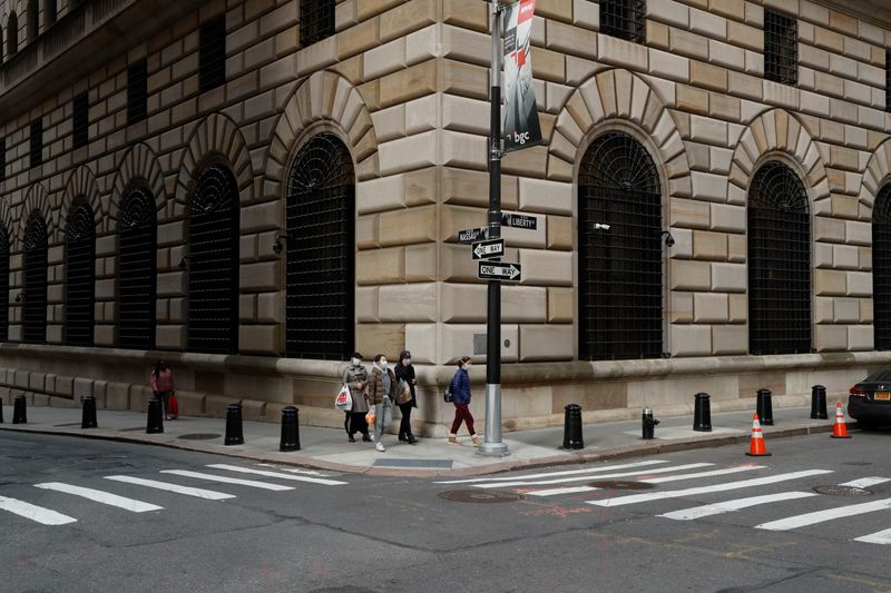 &copy; Reuters. FILE PHOTO: People walk wearing masks outside The Federal Reserve Bank of New York in New York