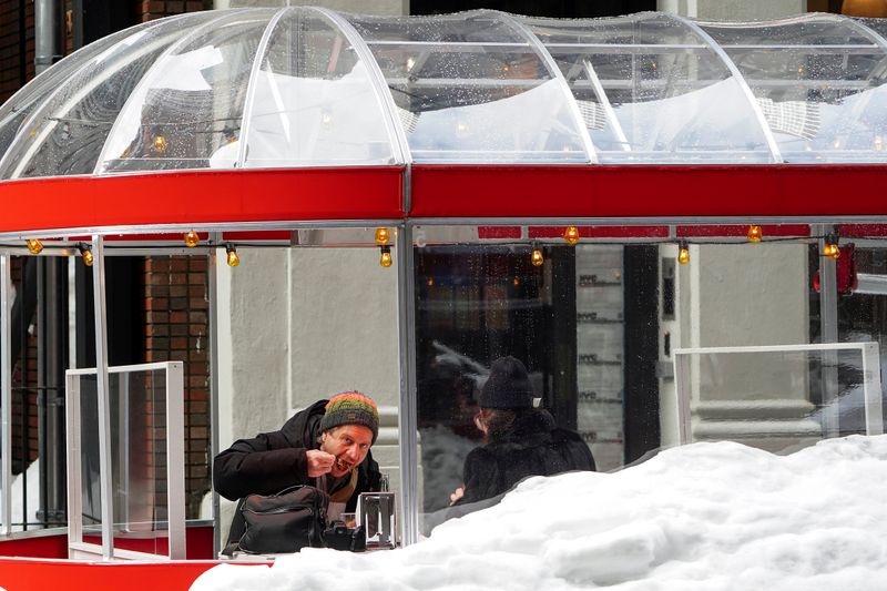 &copy; Reuters. FILE PHOTO: People eat at a taco restaurant outside in a covered enclosure in New York