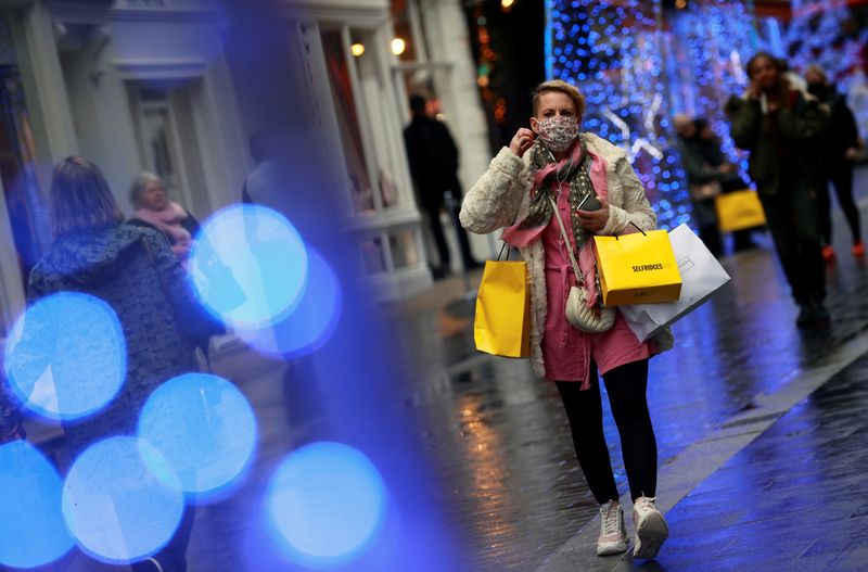 © Reuters. FILE PHOTO: A shopper walks down the street in London