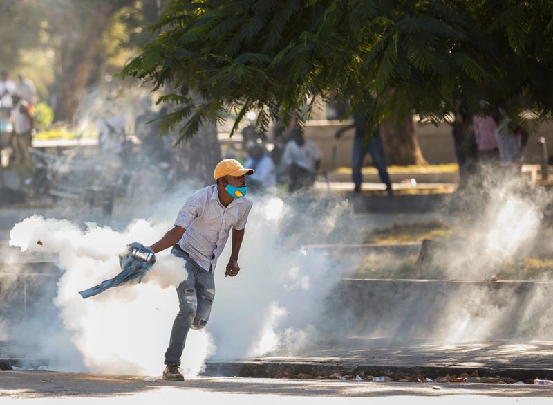 &copy; Reuters. A demonstrator picks up a tear gas canister during protests against Haiti&apos;s President Jovenel Moise, in Port-au-Prince