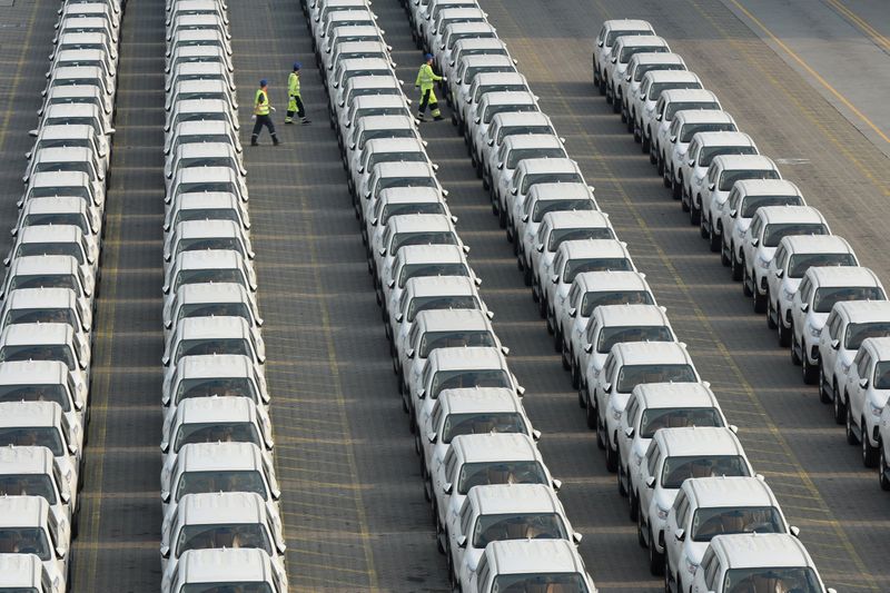 &copy; Reuters. Workers walk among the newly arrived imported Toyota cars at the Shenzhen Dachan Bay Terminals in Guangdong