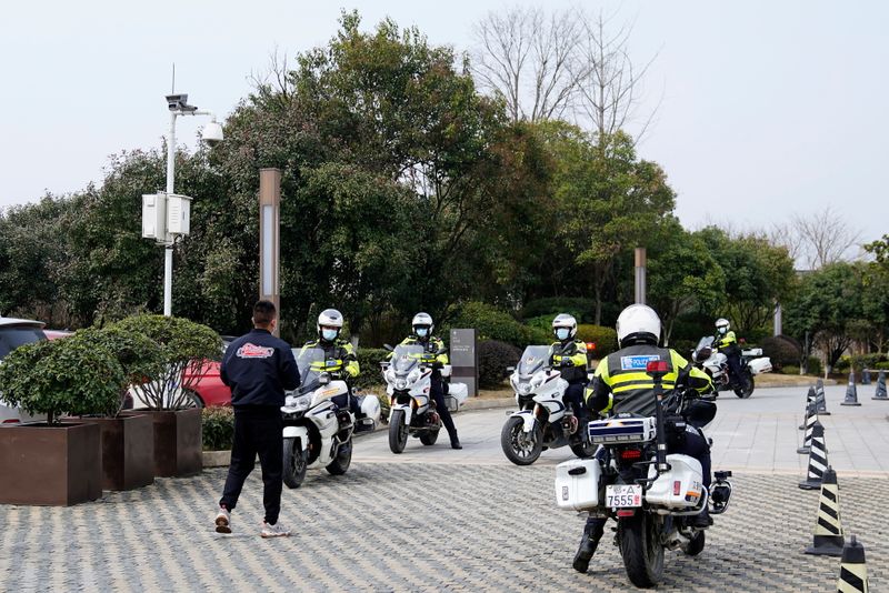 &copy; Reuters. Agentes de policía conducen motocicletas frente a un hotel de Wuhan, provincia de Hubei, China, el 9 de febrero de 2021