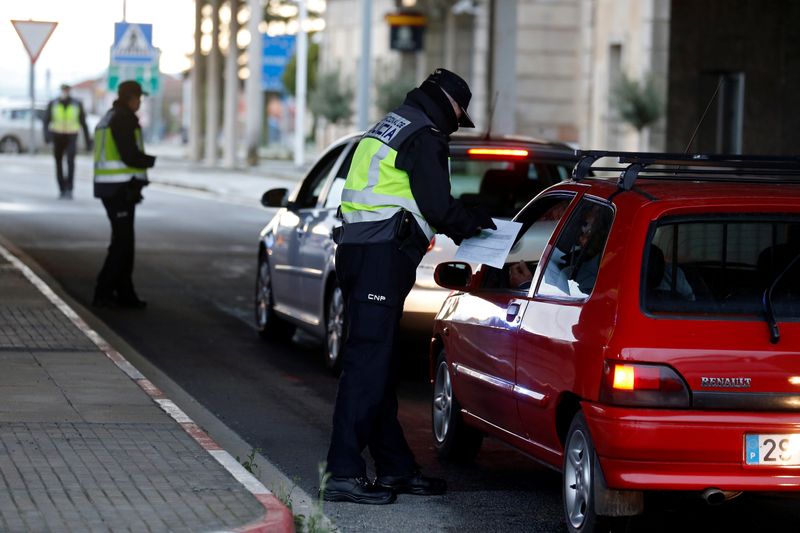 © Reuters. FOTO DE ARCHIVO. Un oficial de policía español revisa un automóvil en la frontera entre Portugal y España, siguiendo una orden del gobierno español para establecer controles en sus fronteras terrestres por el coronavirus, en Vilar Formoso, Portugal