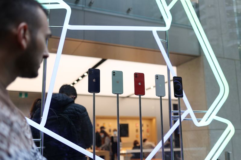 &copy; Reuters. A shopper looks at an iPhone 12 display while waiting in line to enter an Apple Store in Sydney