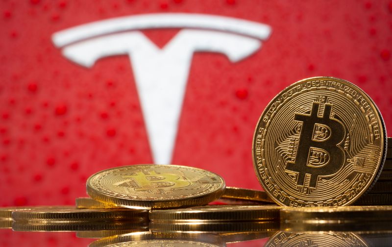 © Reuters. Representação da moeda virtual Bitcoin em frente ao logo da Tesla em imagem ilustrativa