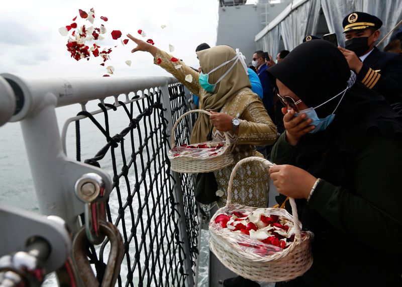 &copy; Reuters. FILE PHOTO: Family members of the passengers of Sriwijaya Air flight SJ 182, which crashed into the sea, react while throwing flowers and petals from the deck of Indonesia&apos;s Naval ship KRI Semarang as they visit the site of the crash to pay their tri