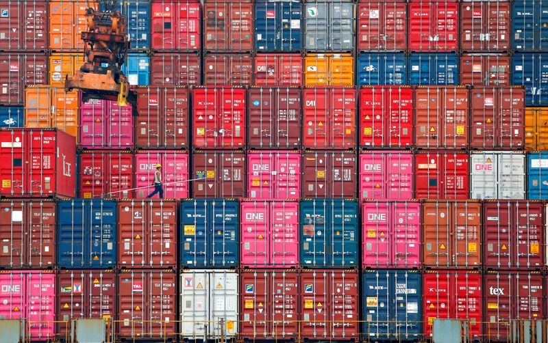 &copy; Reuters. FILE PHOTO: A worker walks on stacks of containers at the Tanjung Priok port in Jakarta