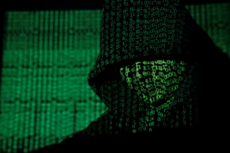 &copy; Reuters. FILE PHOTO: Projection of cyber code on hooded man is pictured in this illustration picture