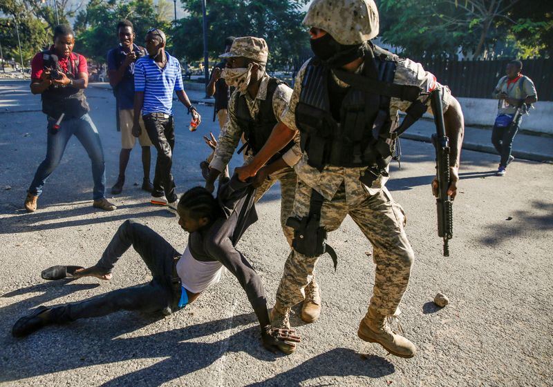 &copy; Reuters. FILE PHOTO: Police officers detain a man during protests against Haiti&apos;s President Jovenel Moise, in Port-au-Prince