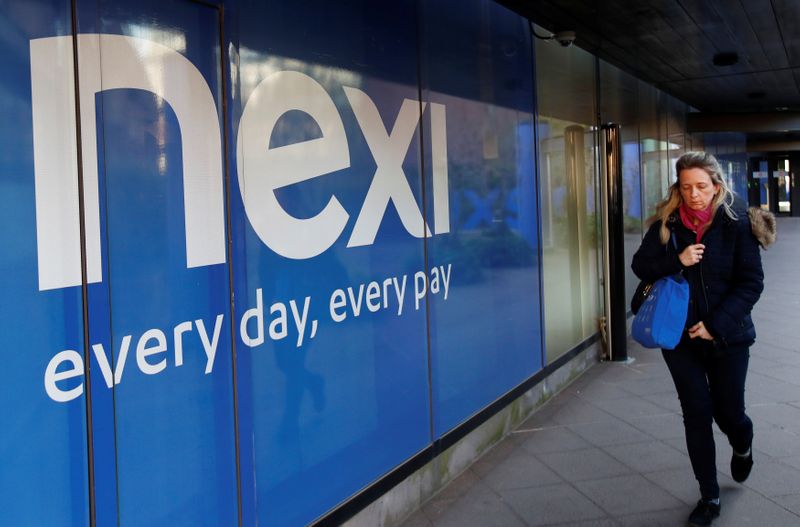 &copy; Reuters. Una donna cammina davanti al logo Nexi a Milano