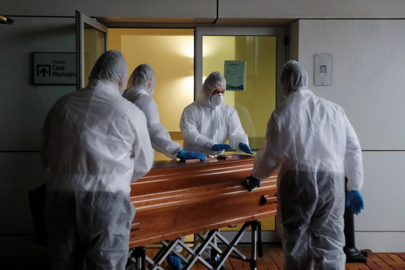 &copy; Reuters. Funcionários de funerária levam caixão vazio para retirar corpo de vítima da Covid em hospital de Cascais