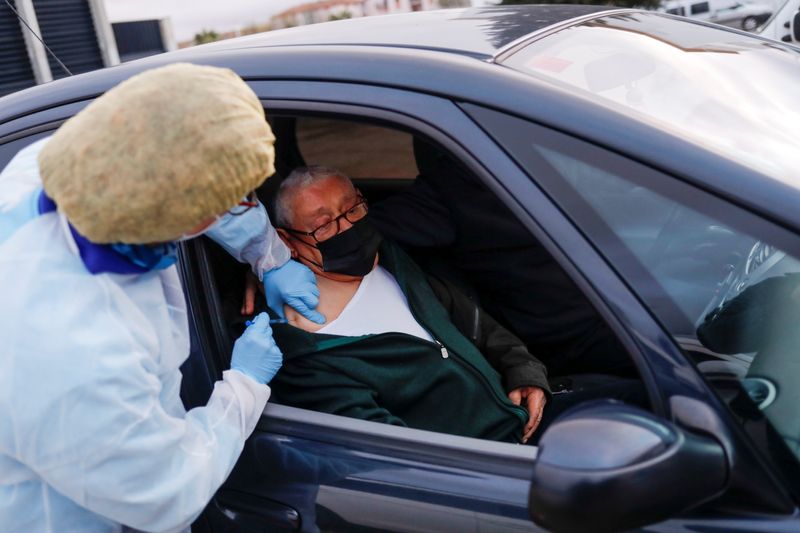 &copy; Reuters. Un anciano recibe la vacuna contra el coronavirus desde un auto en Ronda, España.