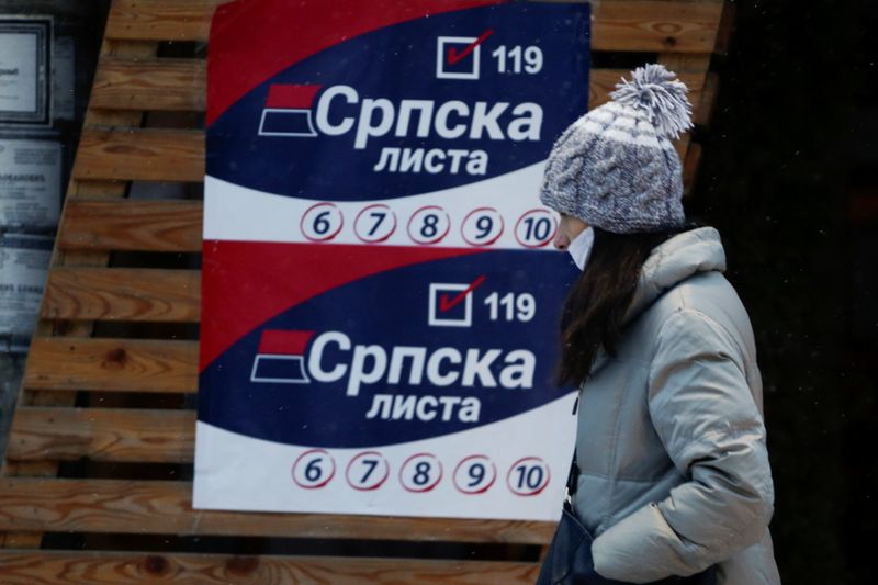 &copy; Reuters. A woman passes by electoral posters of the Serbian political party Serbian List (Srpska Lista), in the town of Gracanica