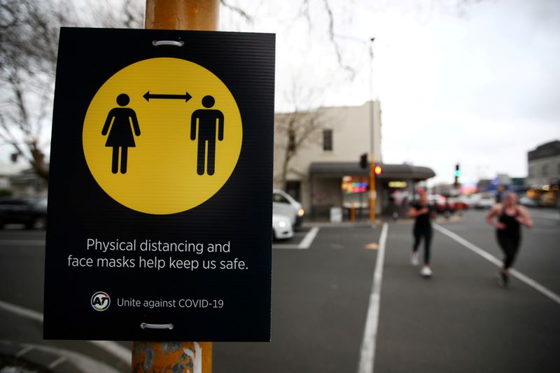 &copy; Reuters. FILE PHOTO: People jog past a social distancing sign in Auckland, New Zealand, August 31, 2020