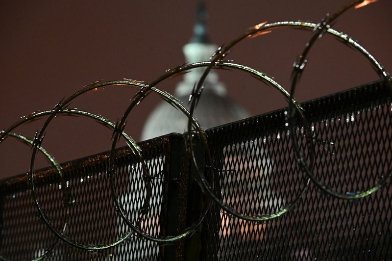 &copy; Reuters. The U.S. Capitol is seen through barbed wire on a security fence after the Senate voted to acquit former U.S. President Donald Trump during his impeachment trial, in Washington