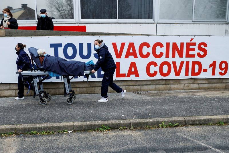 © Reuters. FILE PHOTO: A woman is carried on a stretcher to the COVID-19 vaccination centre during a visit by French Health Minister at the South Ile-de-France Hospital Group, in Melun