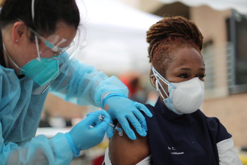 &copy; Reuters. FILE PHOTO: Nurse practitioner Nicole Monk, 44, receives a coronavirus disease (COVID-19) vaccination at the LA Mission homeless shelter on Skid Row, in Los Angeles
