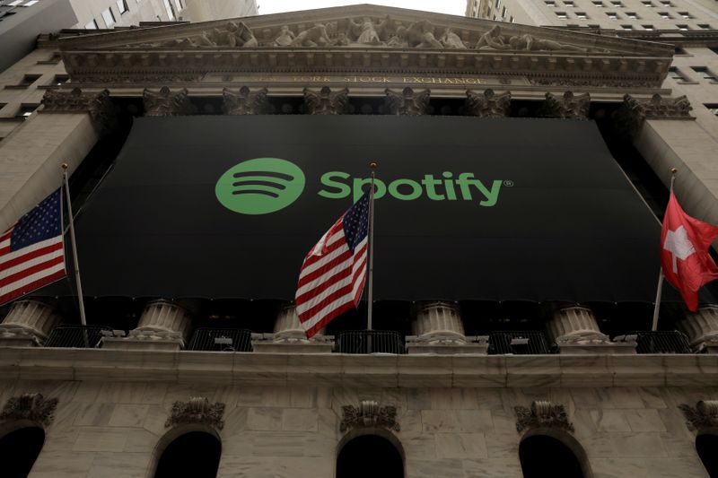 &copy; Reuters. FILE PHOTO: The Spotify logo hangs on the facade of the New York Stock Exchange with U.S. and a Swiss flag as the company lists it&apos;s stock with a direct listing in New York