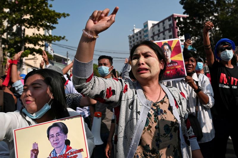 &copy; Reuters. Manifestantes sostienen pancartas con la imagen de la encarcelada líder birmana Aung San Suu Kyi  durante una protesta contra el golpe militar en Rangún, Myanmar.  Febrero 15, 2021. REUTERS/Stringer
