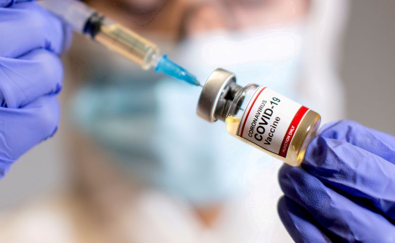 &copy; Reuters. Un operatore sanitario tiene in mano una fialetta che riporta la dicitura &quot;vaccino contro il coronavirus Covid-19&quot;
