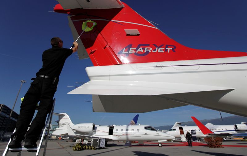 © Reuters. FILE PHOTO: A staff cleans the tail of a Bombardier Learjet aircraft in the static display area before the opening of the  EBACE at Cointrin airport in Geneva