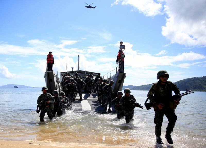 © Reuters. FILE PHOTO: Filipino soldiers disembark from the landing ship before they dock at Motiong Beach as part of a Humanitarian Assistance and Disaster Response scenario in Casiguran