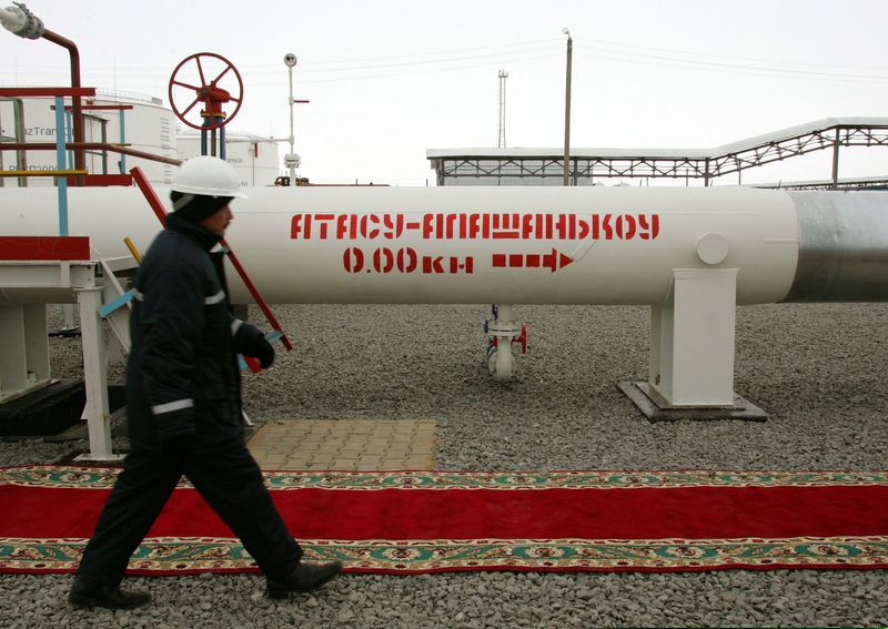 &copy; Reuters. A Kazakh oil worker walks along a newly-opened oil pipeline at a railway station Atasu December 15, ..