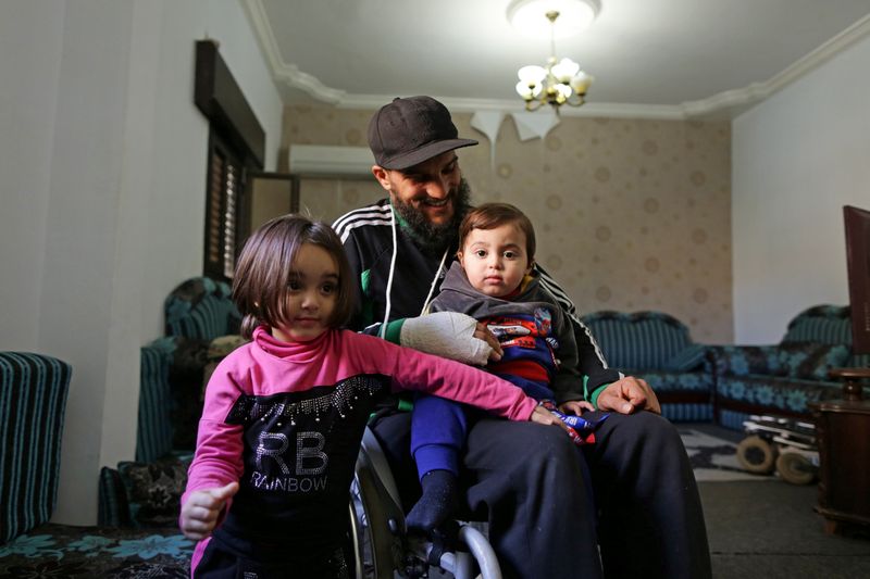 &copy; Reuters. Usama Ali al-aguri sits with his children at their home in Benghazi