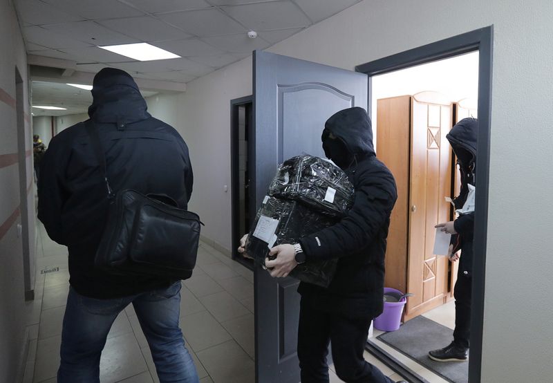 © Reuters. Law enforcement officers leave the office of the independent Belarusian Association of Journalists (BAJ) during a search in Minsk