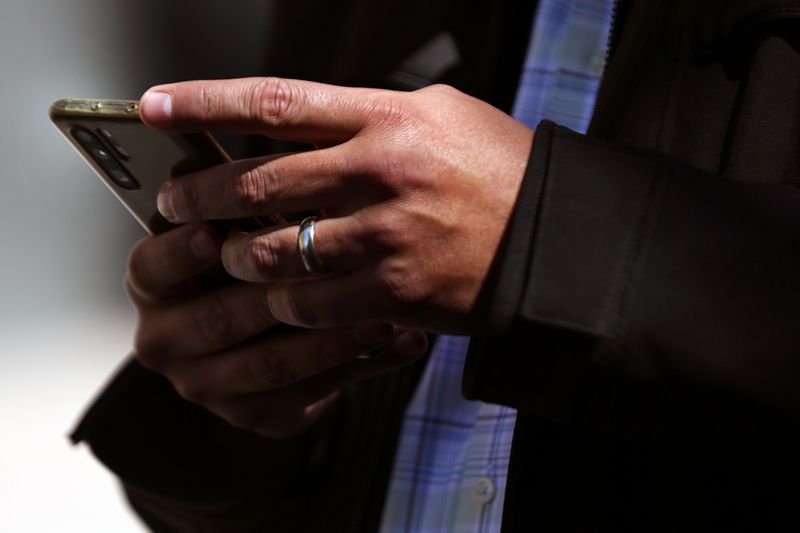 © Reuters. A man holds his mobile phone in downtown Mexico City