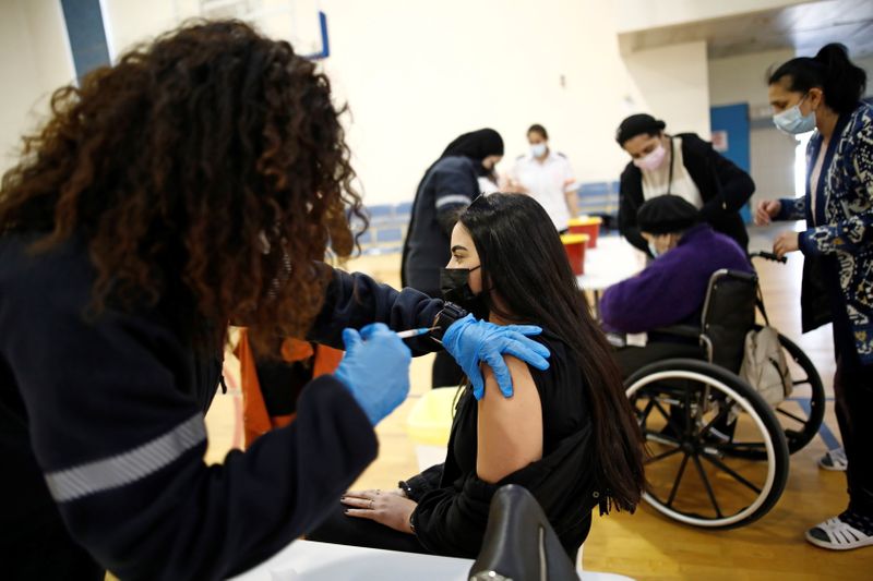 &copy; Reuters. A woman is vaccinated against the coronavirus disease (COVID-19) at a temporary vaccination centre at a sports court in Tel Aviv