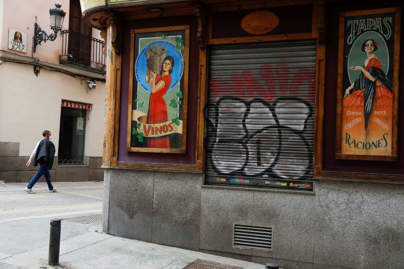 &copy; Reuters. FILE PHOTO: A man walks past a closed bar as the coronavirus disease (COVID-19) outbreak continues in Madrid