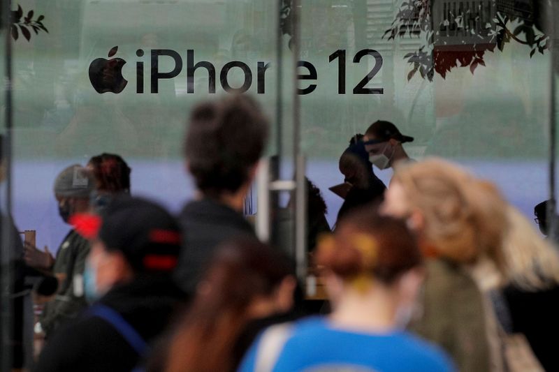 © Reuters. FILE PHOTO: Customers wait in line outside an Apple Store to pick up Apple's new 5G iPhone 12 in Brooklyn, New York