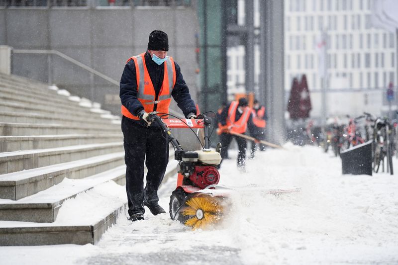 &copy; Reuters. Trabalhadores limpam neve em rua de Berlim