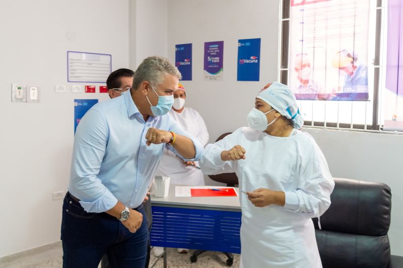 &copy; Reuters. El presidente de Colombia, Iván Duque, y Verónica Machado, jefa de enfermería del Hospital Universitario de Sincelejo, chocan los codos después de que ella recibió una dosis de la vacuna de Pfizer/BioNTech contra el COVID-19 en el inicio de la campa