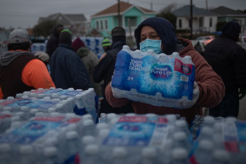 &copy; Reuters. Voluntarios ayudan a distribuir agua a residentes locales en un centro de calentamiento y refugio, Galveston