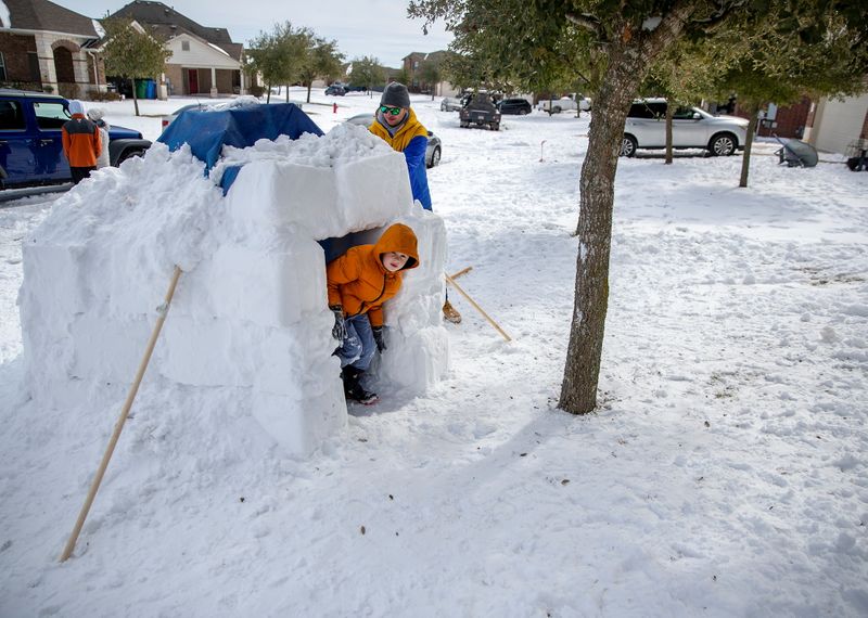 &copy; Reuters. Brett Archibad brinca com o filho no quintal de sua casa em Pflugerville, no Texas