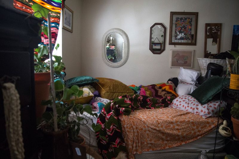 &copy; Reuters. KD Nance huddles under layers of clothing and blankets in their room after winter weather caused electricity blackouts in San Marcos