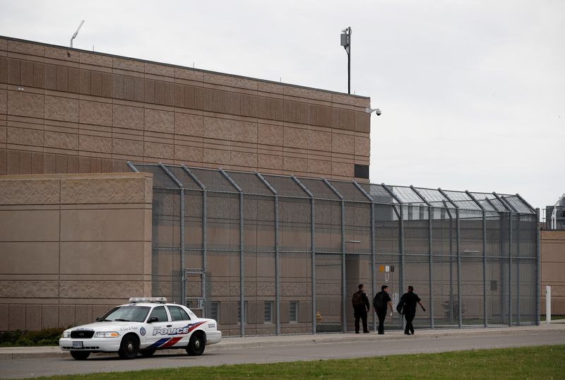 © Reuters. Officers walk by a police car in front of the Toronto South Detention Centre in Toronto