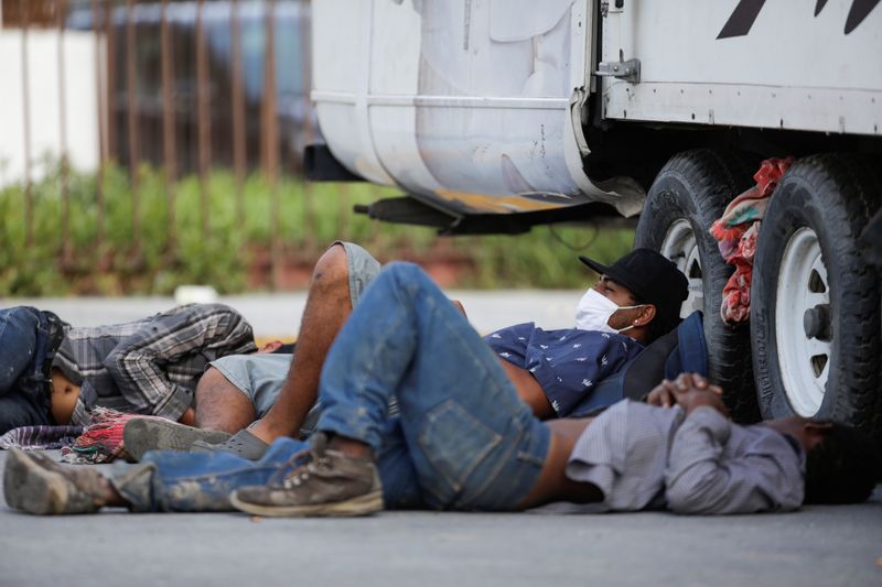 &copy; Reuters. Imagen de archivo. Migrantes descansan junto a un camión frente al albergue de migrantes Casa INDI, donde algunos contrajeron el coronavirus, en Monterrey
