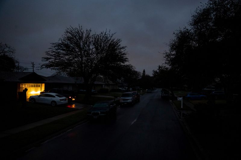 © Reuters. A car idles in a driveway on Jordan Drive, a street with no power in the early morning in Corpus Christi