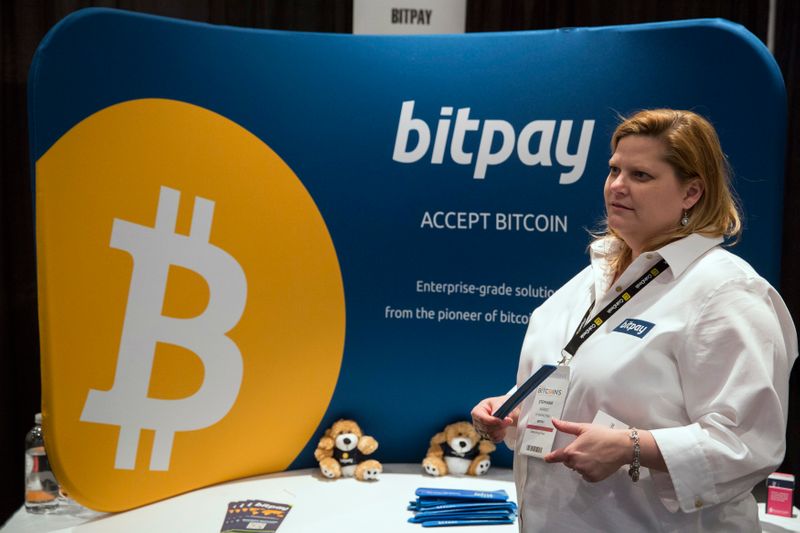 &copy; Reuters. A woman explains how bitpay, a company designed to help companies use virtual currency, to attendee during Inside Bitcoins: The Future of Virtual Currency Conference in New York