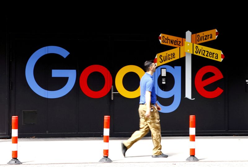 © Reuters. FILE PHOTO: A man walks past a logo of Google in Zurich