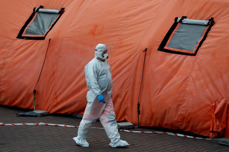 &copy; Reuters. A paramedic walks amid the coronavirus disease (COVID-19) outbreak, in front of a hospital in Warsaw